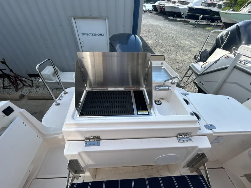 Slide: The Image of Outdoor grill on 2020 Ranger Tugs R-27 boat, docked near other vessels. - 9