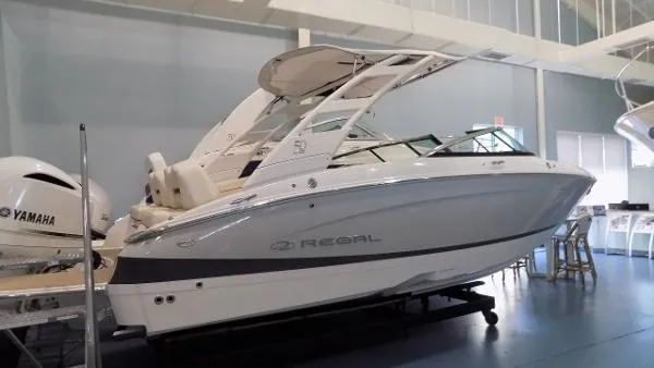 Slide: The Image of 2022 Regal LX4 boat in showroom, side view, featuring sleek design and Yamaha engine. - 1