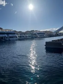 Slide: The Image of Boats docked at a marina under a bright sun, reflecting on the water. - 33