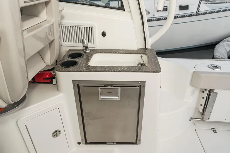 Slide: The Image of 2019 Boston Whaler 315 Conquest boat interior with sink and storage area. - 102