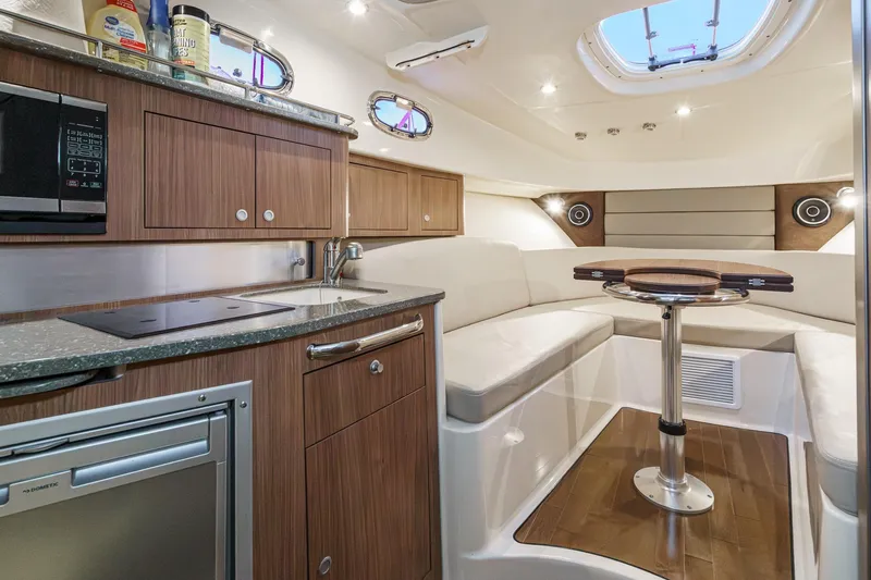 Slide: The Image of Luxurious interior of 2019 Boston Whaler 315 Conquest boat with modern kitchen and seating area. - 105