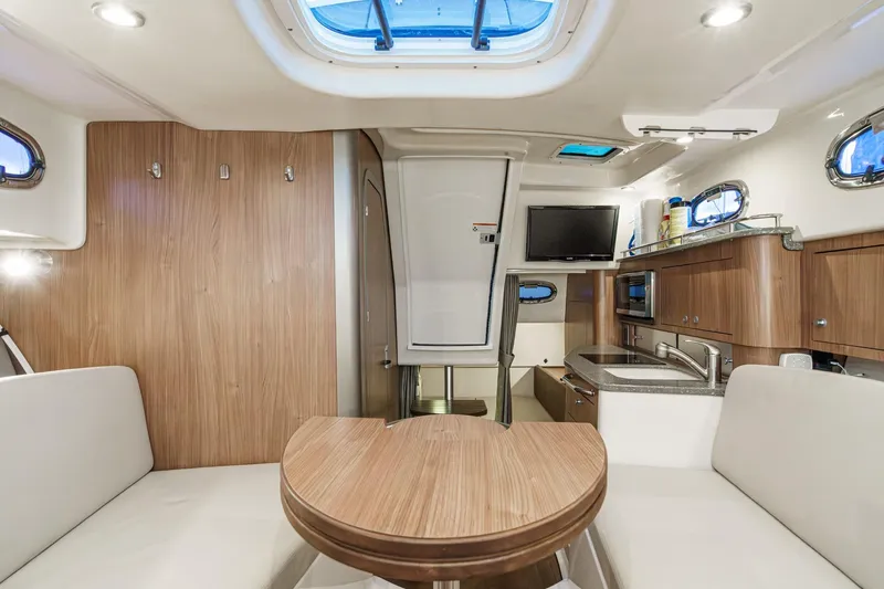 Slide: The Image of 2019 Boston Whaler 315 Conquest cabin interior with wood finishes and modern amenities. - 108
