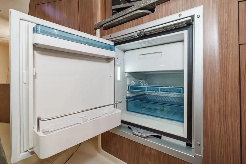 Slide: The Image of Open refrigerator inside 2019 Boston Whaler 315 Conquest boat, showcasing modern interior design. - 109