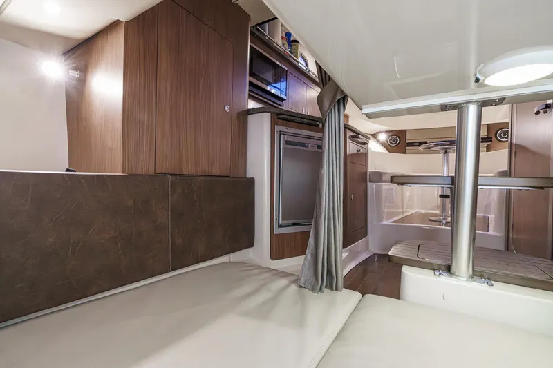 Slide: The Image of Interior of 2019 Boston Whaler 315 Conquest, featuring modern wood cabinetry and seating. - 115