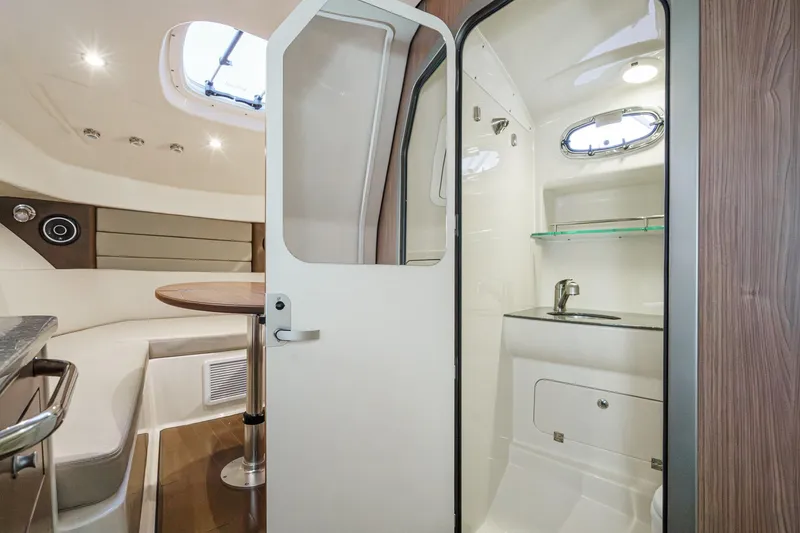 Slide: The Image of Interior of 2019 Boston Whaler 315 Conquest, featuring a compact cabin and kitchenette. - 116