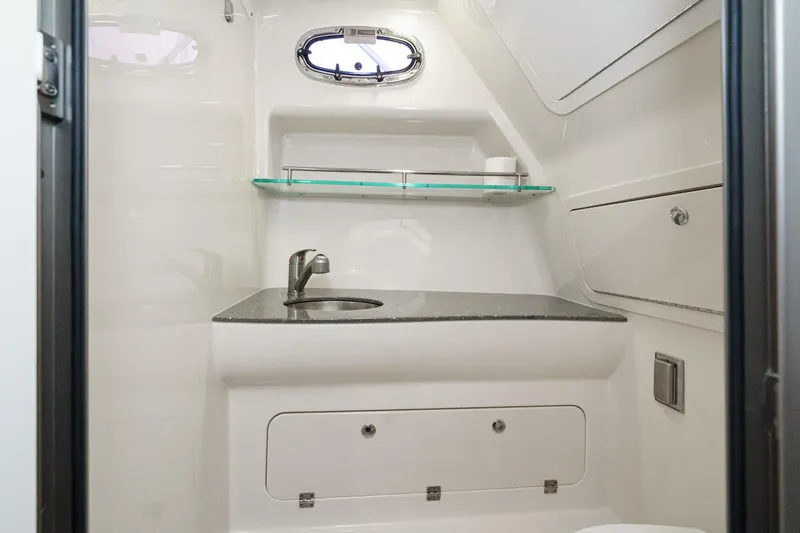 Slide: The Image of 2019 Boston Whaler 315 Conquest bathroom with sink, shelf, and porthole window. - 117