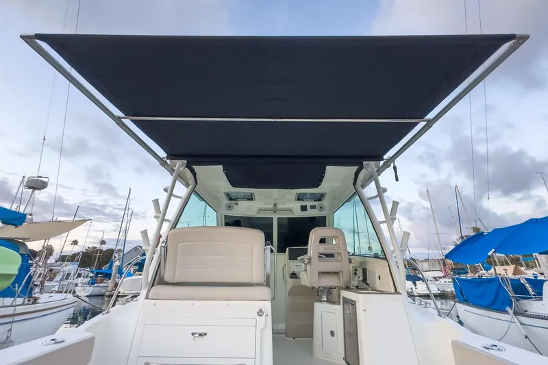 Slide: The Image of 2019 Boston Whaler 315 Conquest boat with canopy, docked at marina. - 119