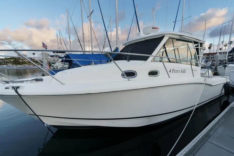 Slide: The Image of 2019 Boston Whaler 315 Conquest docked at marina, surrounded by sailboats. - 121