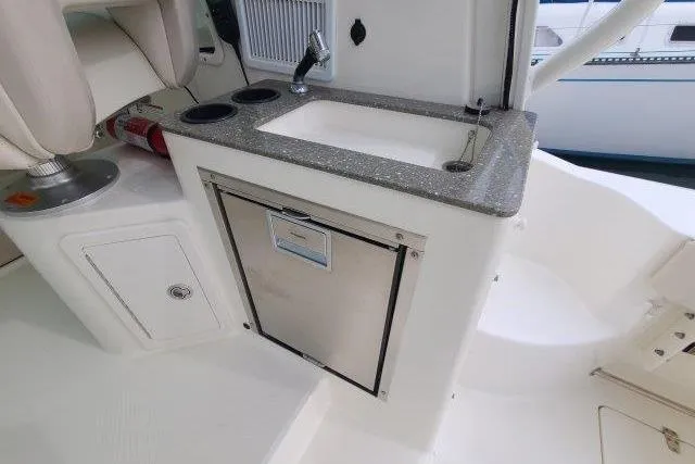 Slide: The Image of 2019 Boston Whaler 315 Conquest boat kitchenette with sink and storage. - 25