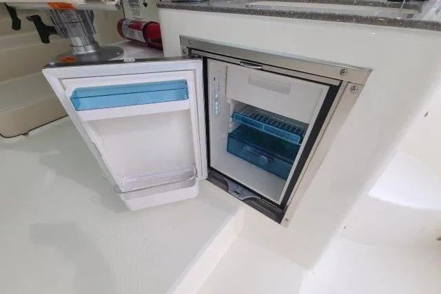Slide: The Image of Open mini fridge on 2019 Boston Whaler 315 Conquest boat, showcasing interior storage. - 27