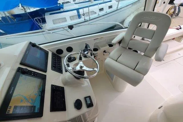 Slide: The Image of 2019 Boston Whaler 315 Conquest helm with navigation screens and captain's chair. - 29