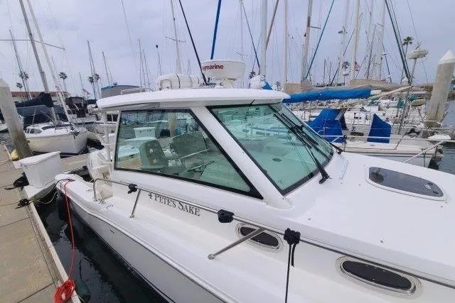Slide: The Image of 2019 Boston Whaler 315 Conquest docked at marina with sailboats in background. - 3