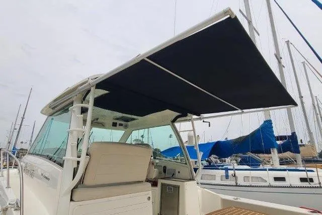 Slide: The Image of 2019 Boston Whaler 315 Conquest boat with extended canopy at marina. - 42