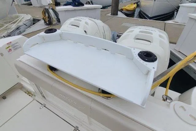 Slide: The Image of 2019 Boston Whaler 315 Conquest boat with dual outboard engines at dock. - 51