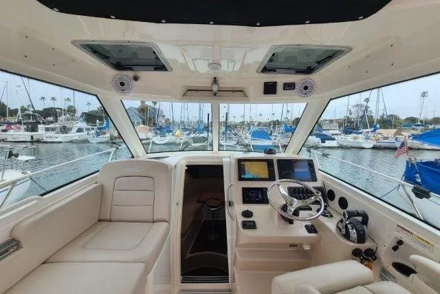 Slide: The Image of 2019 Boston Whaler 315 Conquest helm with modern navigation, docked in a marina. - 52