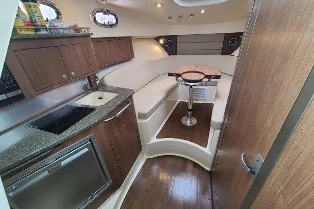 Slide: The Image of 2019 Boston Whaler 315 Conquest cabin interior with kitchenette and seating area. - 53