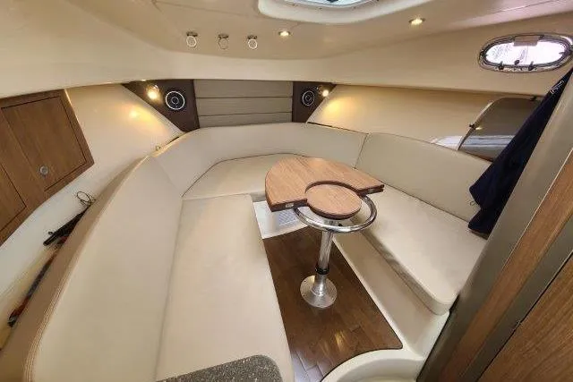 Slide: The Image of 2019 Boston Whaler 315 Conquest cabin interior with seating and table. - 54