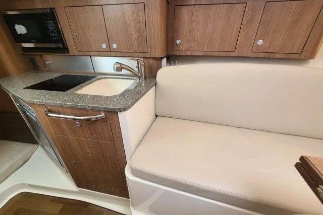 Slide: The Image of 2019 Boston Whaler 315 Conquest interior with kitchenette and seating area. - 57