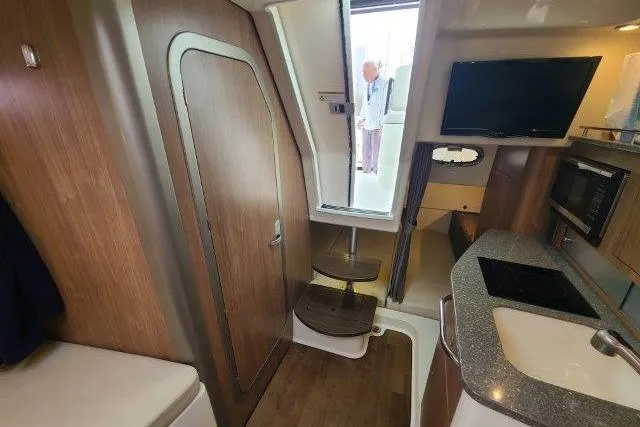 Slide: The Image of Interior of 2019 Boston Whaler 315 Conquest, featuring kitchenette and stairs to deck. - 63