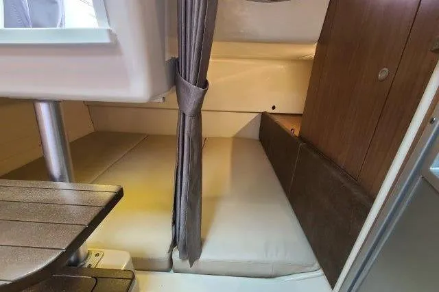 Slide: The Image of 2019 Boston Whaler 315 Conquest cabin interior with bed and wooden accents. - 64