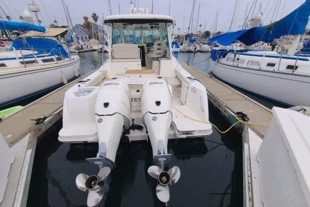 Slide: The Image of 2019 Boston Whaler 315 Conquest docked with twin outboard engines in a marina. - 7