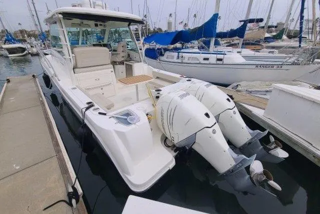Slide: The Image of 2019 Boston Whaler 315 Conquest boat docked at marina with twin engines. - 8