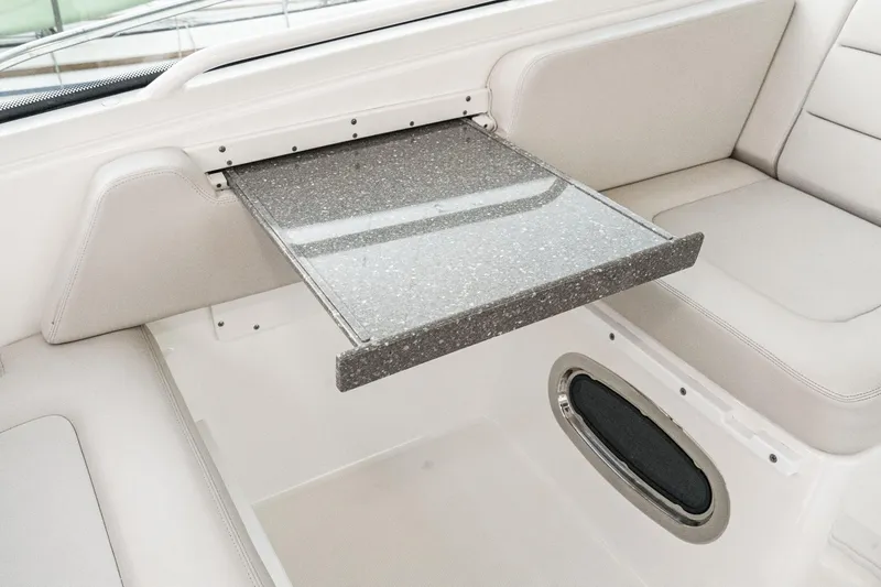 Slide: The Image of 2019 Boston Whaler 315 Conquest interior with a retractable table and cushioned seating. - 91