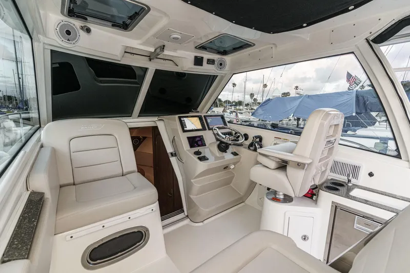 Slide: The Image of Interior of 2019 Boston Whaler 315 Conquest boat, featuring helm and seating area. - 93