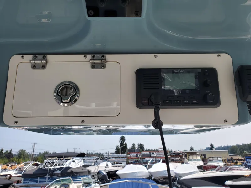 Slide: The Image of 2022 Sailfish 220 WAC boat console with Garmin radio, docked at marina. - 13