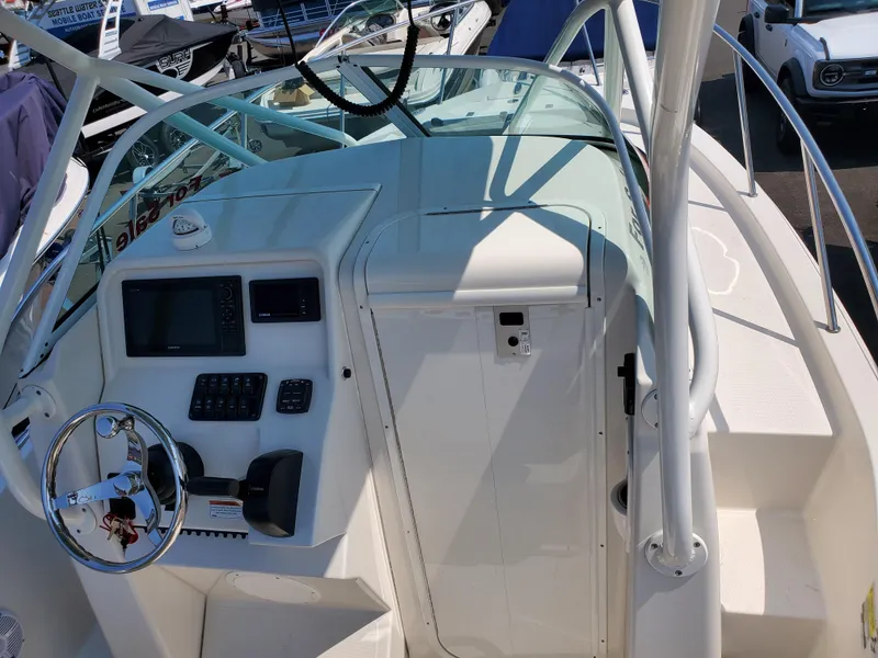 Slide: The Image of 2022 Sailfish 220 WAC boat cockpit with steering wheel and control panel. - 3