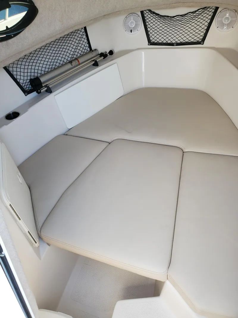 Slide: The Image of 2022 Sailfish 220 WAC cabin interior with cushioned seating and storage nets. - 6