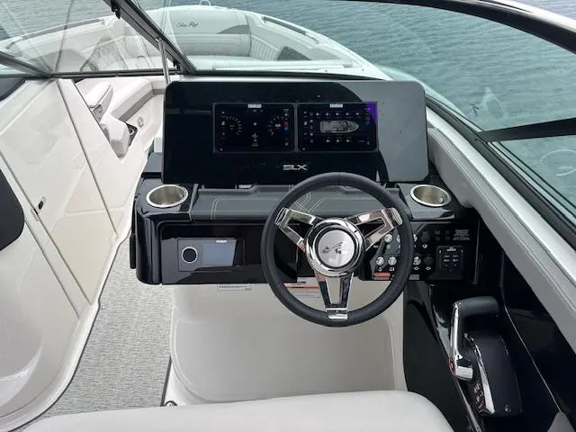 Slide: The Image of 2024 Sea Ray SLX 280 boat helm with modern controls and steering wheel. - 23