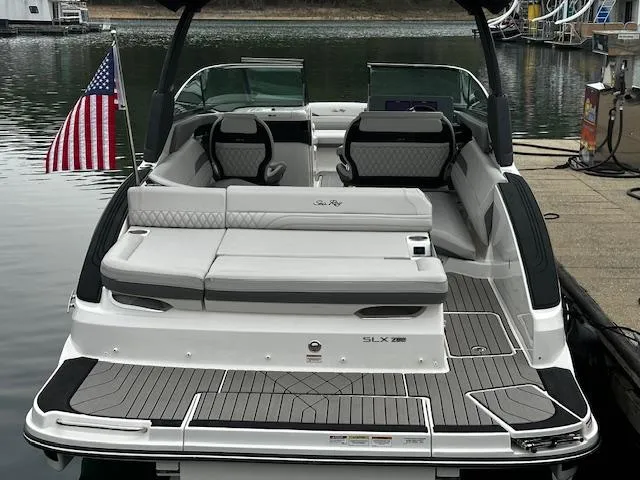 Slide: The Image of 2024 Sea Ray SLX 280 luxury boat docked, rear view with American flag. - 35