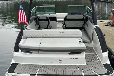Slide: The Image of 2024 Sea Ray SLX 280 boat with American flag, docked on calm water. - 36
