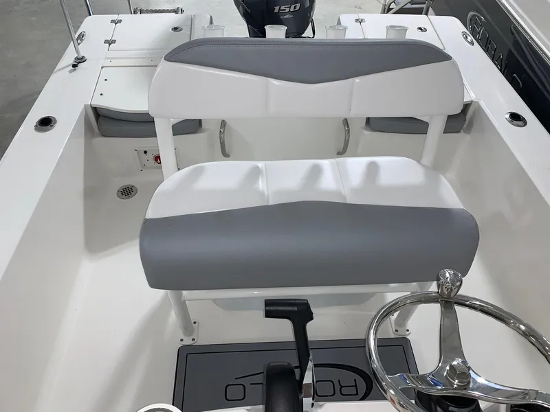 Slide: The Image of 2024 Robalo 206 Cayman boat interior with gray and white seating and steering wheel. - 16