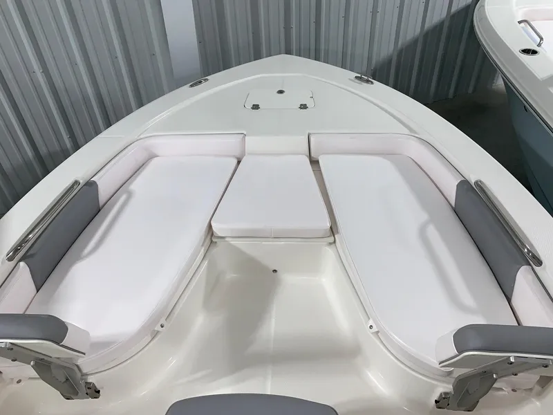 Slide: The Image of 2024 Robalo 206 Cayman boat with white cushioned seating in the bow area. - 24