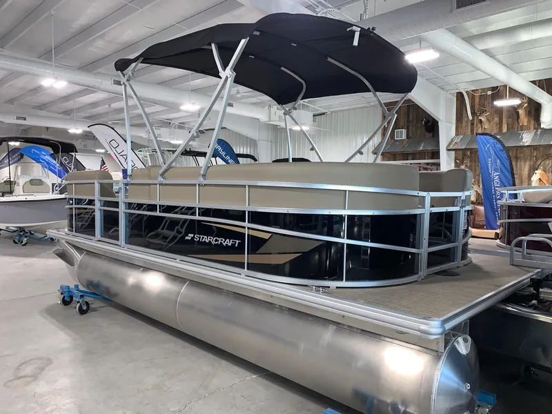 Slide: The Image of 2024 Starcraft LX20 R pontoon boat displayed indoors. - 0