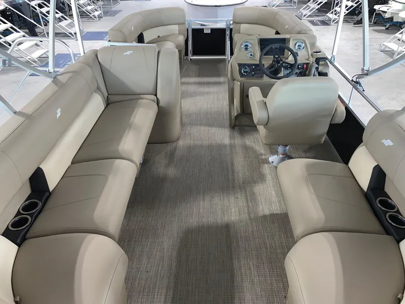 Slide: The Image of 2024 Starcraft LX20 R pontoon boat interior with beige seating and captain's chair. - 2