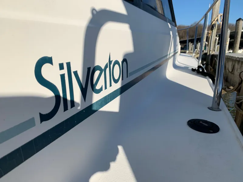 Slide: The Image of 1992 Silverton 34 Aft Cabin Motor Yacht, docked, showcasing brand logo and sleek design. - 10