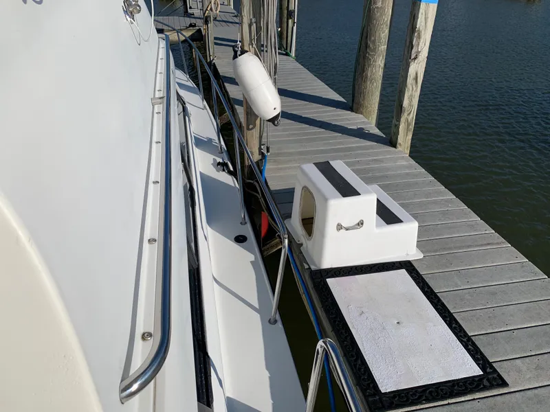 Slide: The Image of 1992 Silverton 34 Aft Cabin Motor Yacht docked, showing side view with fender and step. - 2