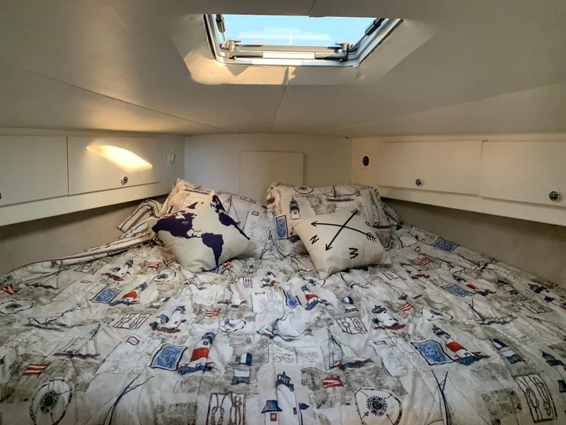 Slide: The Image of Cozy cabin interior of 1992 Silverton 34 Aft Cabin Motor Yacht with nautical-themed bedding. - 28