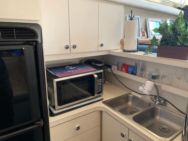 Slide: The Image of 1992 Silverton 34 Aft Cabin Motor Yacht kitchen with microwave, dual sink, and storage cabinets. - 34