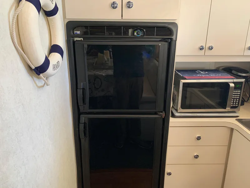 Slide: The Image of Kitchen area of a 1992 Silverton 34 Aft Cabin Motor Yacht with fridge and microwave. - 35