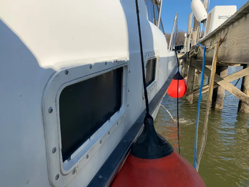 Slide: The Image of 1992 Silverton 34 Aft Cabin Motor Yacht docked with red fenders, side view. - 4
