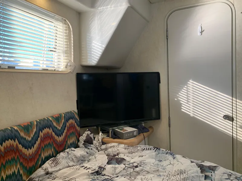 Slide: The Image of Interior of 1992 Silverton 34 Aft Cabin Motor Yacht with TV and patterned bedding. - 46