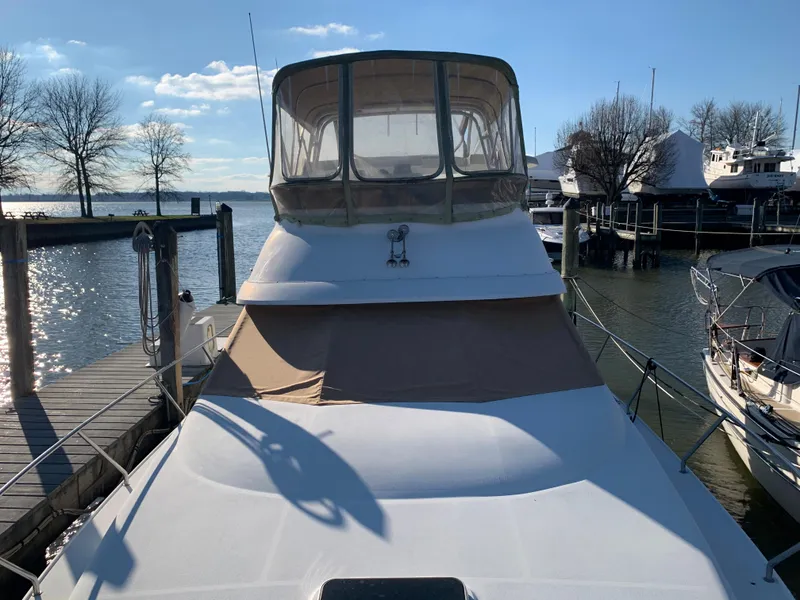 Slide: The Image of 1992 Silverton 34 Aft Cabin Motor Yacht docked at marina under clear sky. - 8