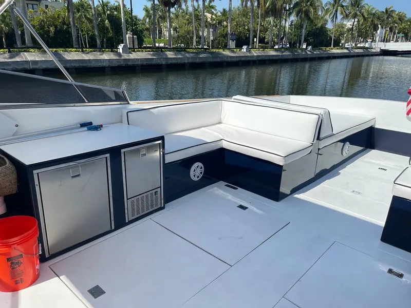 Slide: The Image of 1984 Magnum Marine boat with white seating and storage, docked by a canal. - 12