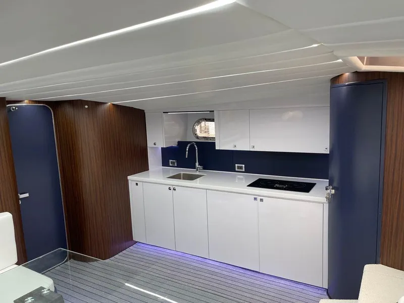 Slide: The Image of Modern kitchen area in a 1984 Magnum Marine boat with sleek white cabinets and blue accents. - 4