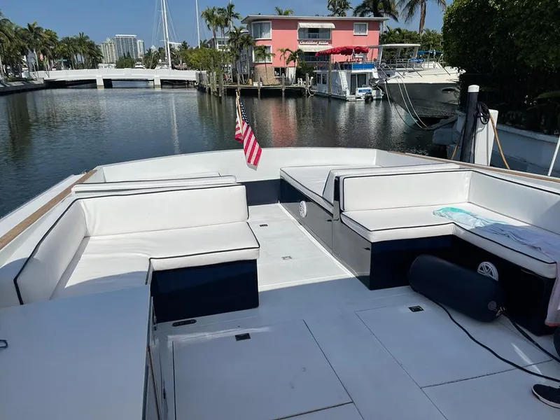 Slide: The Image of 1984 Magnum Marine boat with white seating, docked in a canal with waterfront homes. - 8