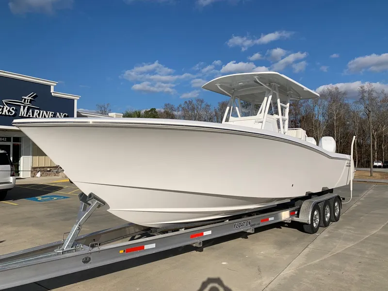 Slide: The Image of 2024 Invincible 33 Open Fisherman boat on a trailer at a marina. - 2